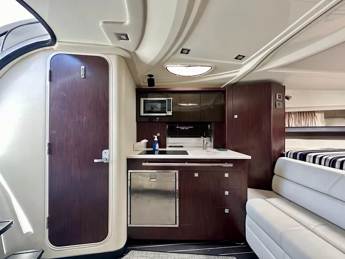 Magic Ten Yacht Photos Pics Interior of 2015 Monterey 335 Sport Yacht with kitchenette and seating area.