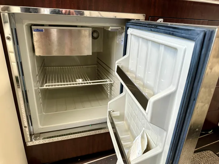 Magic Ten Yacht Photos Pics Open refrigerator inside 2015 Monterey 335 Sport Yacht, featuring empty shelves and door compartments.