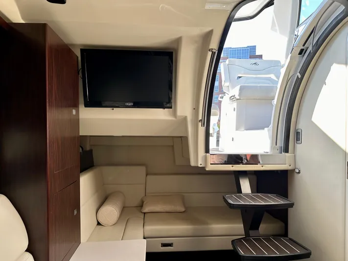 Magic Ten Yacht Photos Pics Interior of 2015 Monterey 335 Sport Yacht with TV, seating, and stairs.