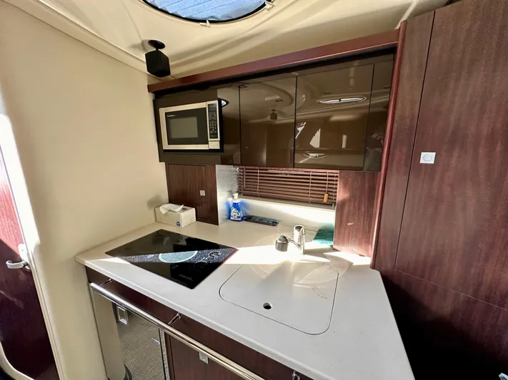 Magic Ten Yacht Photos Pics 2015 Monterey 335 Sport Yacht kitchen with microwave, stove, and modern cabinetry.