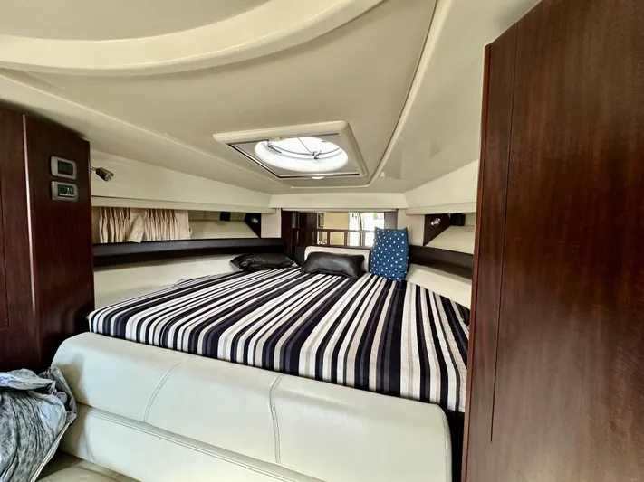 Magic Ten Yacht Photos Pics Interior cabin of 2015 Monterey 335 Sport Yacht with striped bedding and skylight.