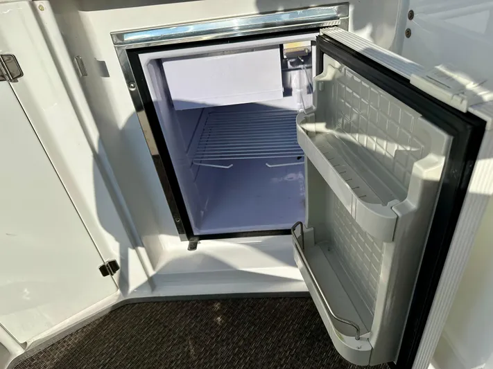 Magic Ten Yacht Photos Pics Open mini fridge on 2015 Monterey 335 Sport Yacht, showing interior shelves and door storage.
