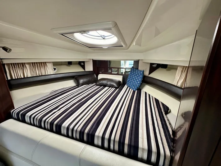 Magic Ten Yacht Photos Pics 2015 Monterey 335 Sport Yacht cabin with striped bedding and skylight.