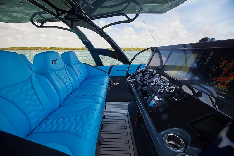  Yacht Photos Pics Luxurious interior of 2022 Midnight Express 43' Solstice boat with blue seating and advanced dashboard.