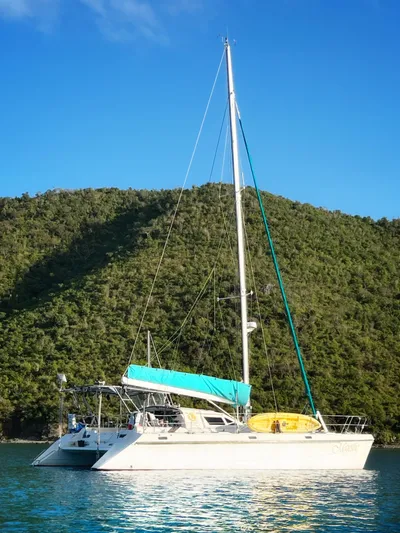 Majestic Yacht Photos Pics Sailing catamaran St Francis 44 MKII, 1999, anchored in scenic bay with lush hills.