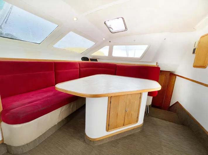 Majestic Yacht Photos Pics Interior of 1999 St Francis 44 MKII yacht with red seating and wooden table.