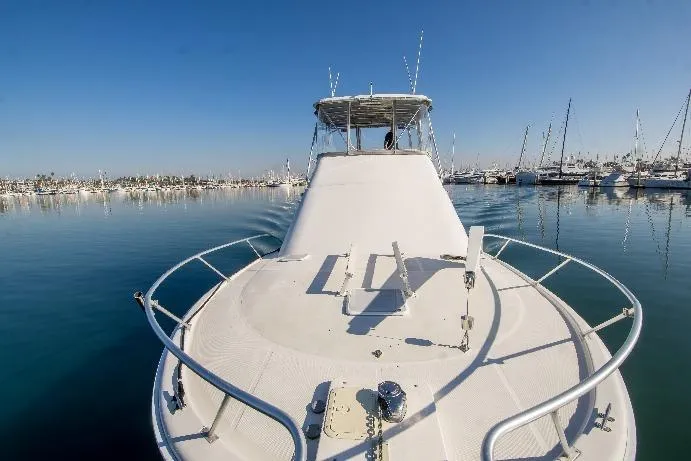 Lost Boys Yacht Photos Pics 2002 Luhrs 36 Convertible yacht on calm water, marina in background.