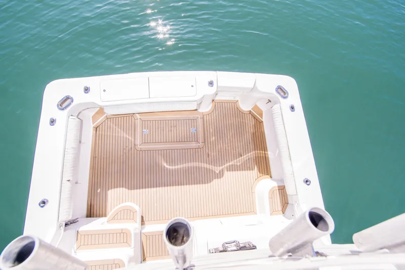 Lost Boys Yacht Photos Pics 2002 Luhrs 36 Convertible boat deck with teak flooring, overlooking calm blue water.