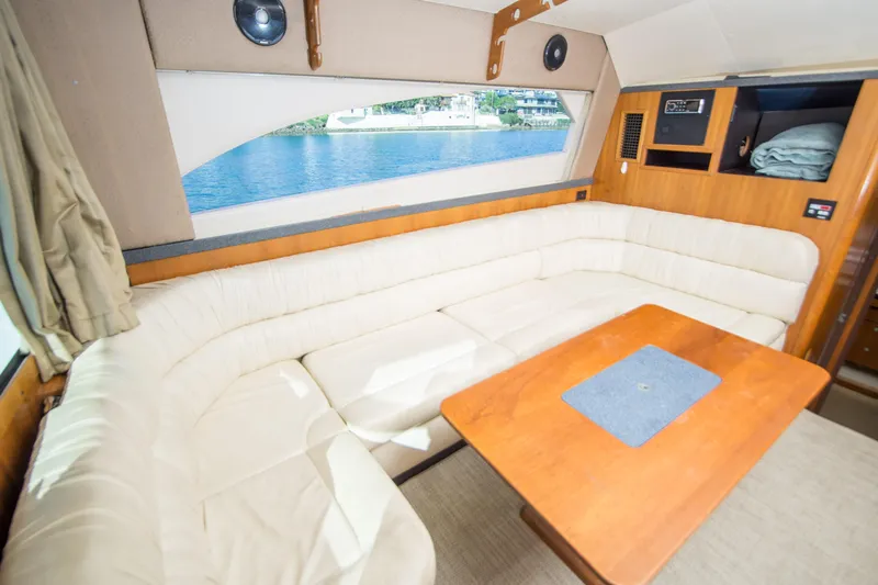 Lost Boys Yacht Photos Pics Interior of 2002 Luhrs 36 Convertible yacht with beige seating and wooden table.