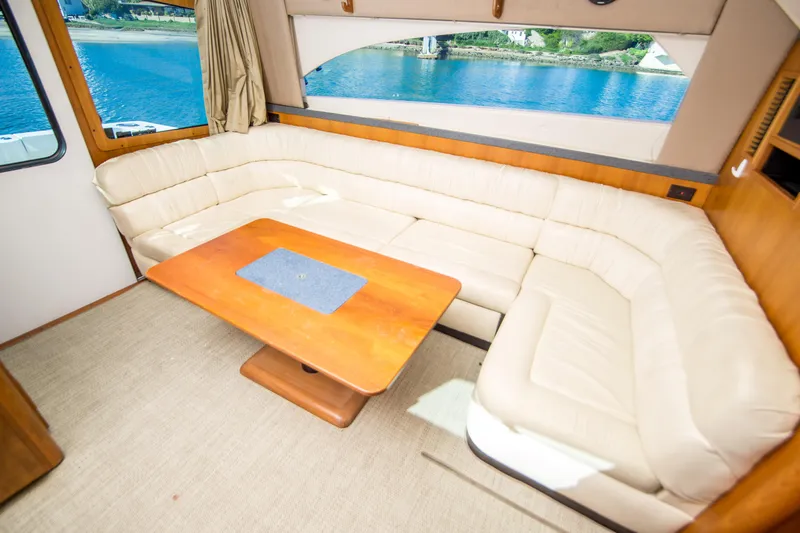 Lost Boys Yacht Photos Pics Interior of 2002 Luhrs 36 Convertible yacht with cream leather seating and wooden table.