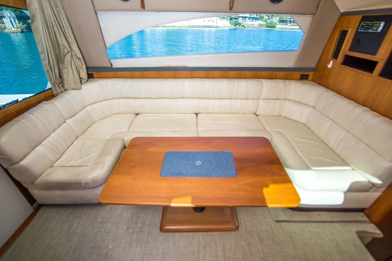 Lost Boys Yacht Photos Pics Interior of 2002 Luhrs 36 Convertible yacht with beige seating and wooden table.