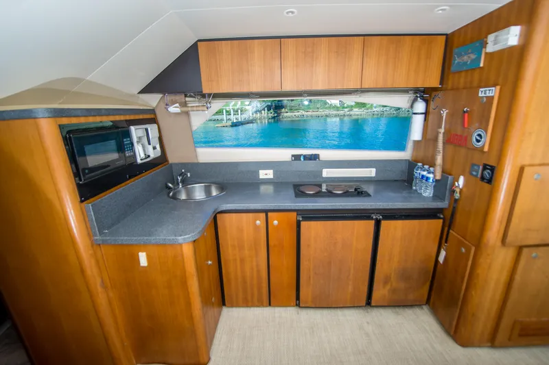 Lost Boys Yacht Photos Pics 2002 Luhrs 36 Convertible yacht kitchen with wood cabinets and ocean view window.