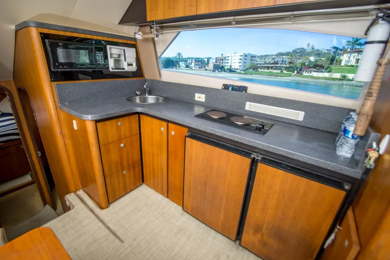 Lost Boys Yacht Photos Pics 2002 Luhrs 36 Convertible yacht kitchen with wood cabinets and modern appliances.