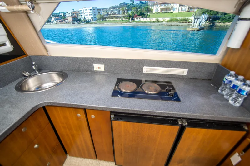 Lost Boys Yacht Photos Pics 2002 Luhrs 36 Convertible yacht kitchen with sink, stove, and waterfront view.