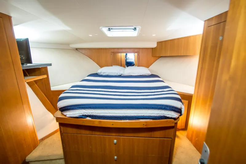 Lost Boys Yacht Photos Pics Luxurious cabin interior of 2002 Luhrs 36 Convertible yacht with cozy bed and wooden finish.