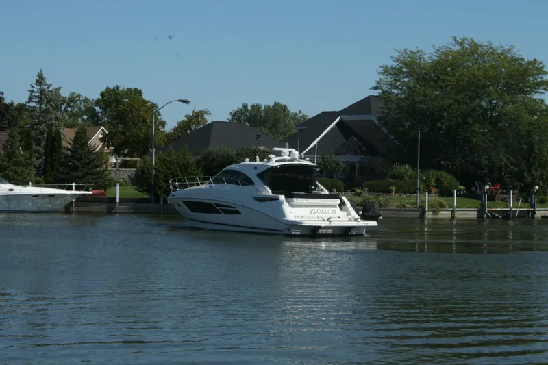  Yacht Photos Pics 2014 Sea Ray 510 Sundancer yacht cruising near waterfront homes.