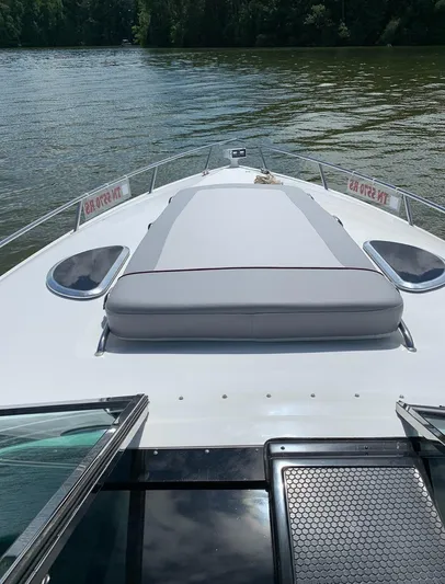 New Engines 2021 Yacht Photos Pics Cobalt 360 boat deck, 2005 model, on calm water with lush greenery in background.