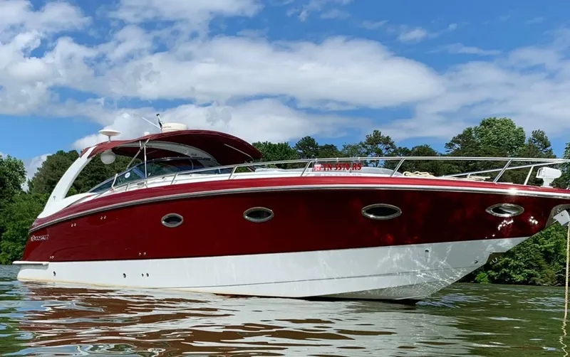 New Engines 2021 Yacht Photos Pics 2005 Cobalt 360 boat on water, red and white design, clear sky, lush greenery background.