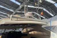 2007 Astondoa 53 Open yacht in a covered marina, featuring Garmin equipment and a flag.