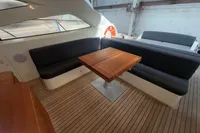 Astondoa 53 Open 2007 yacht interior with wooden table and black seating.