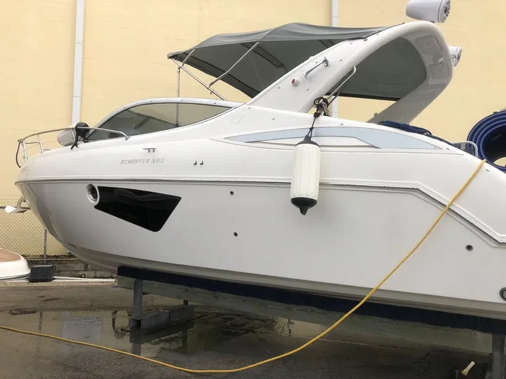  Yacht Photos Pics 2021 Schaefer 303 boat on dry dock, white exterior, covered cockpit, side view.