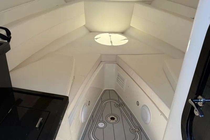  Yacht Photos Pics Interior cabin of 2021 Schaefer 303 boat with white seating and circular window.