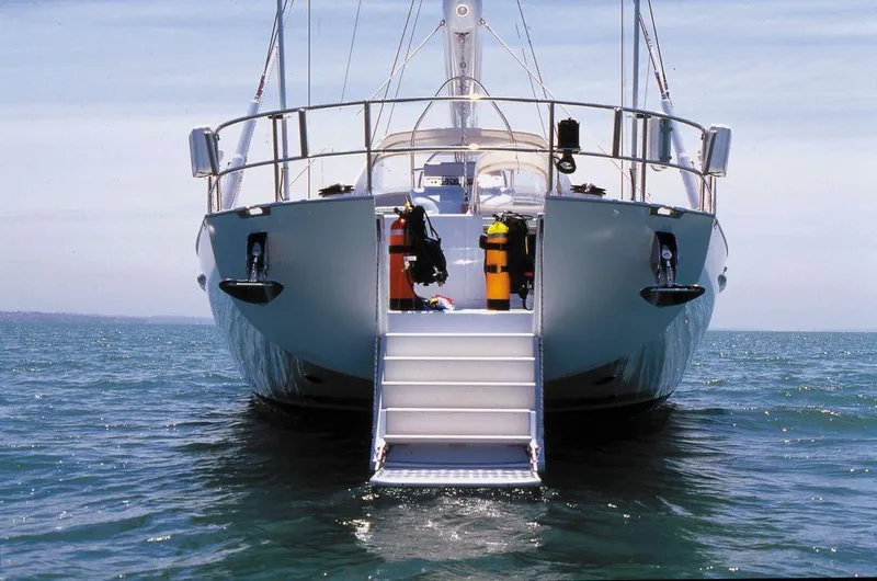 Sorcerer II Yacht Photos Pics Cookson Frers 1998 yacht with diving equipment on rear deck, anchored in calm sea.