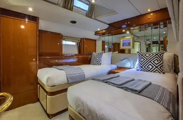 Sorcerer II Yacht Photos Pics Luxurious cabin interior of 1998 Cookson Frers yacht with twin beds and elegant wood finish.