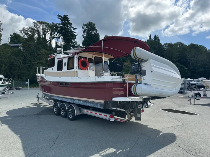  Yacht Photos Pics 2014 Ranger Tugs R-31S boat on trailer, red hull, inflatable dinghy attached, parked outdoors.