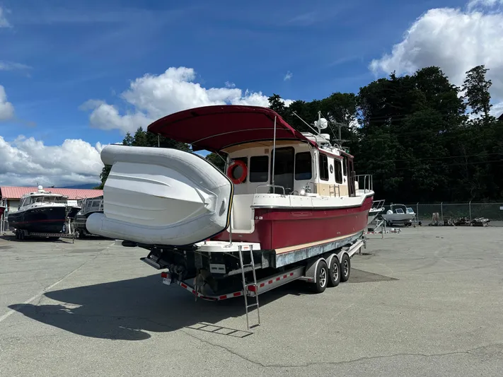  Yacht Photos Pics 2014 Ranger Tugs R-31S boat on trailer, red hull, parked outdoors under blue sky.
