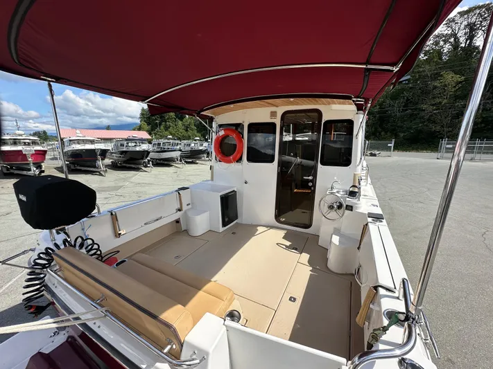 Yacht Photos Pics 2014 Ranger Tugs R-31S boat interior with red canopy and seating area.