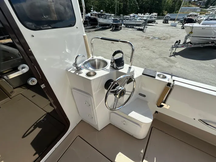  Yacht Photos Pics 2014 Ranger Tugs R-31S helm with sink and steering wheel in a marina setting.