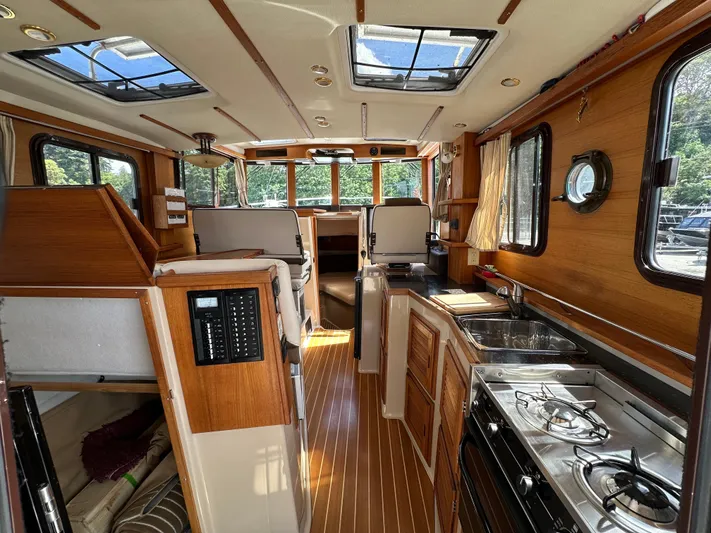  Yacht Photos Pics Interior of 2014 Ranger Tugs R-31S, featuring wood paneling, kitchen, and seating area.