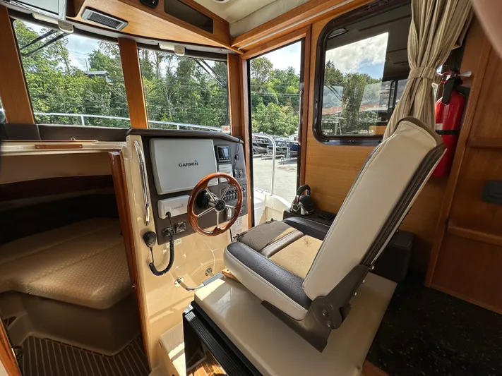  Yacht Photos Pics 2014 Ranger Tugs R-31S helm with Garmin navigation, wooden interior, and captain's chair.