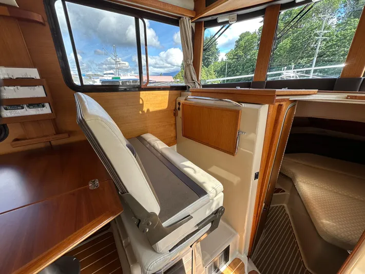  Yacht Photos Pics 2014 Ranger Tugs R-31S interior with helm seat, wooden accents, and cabin view.