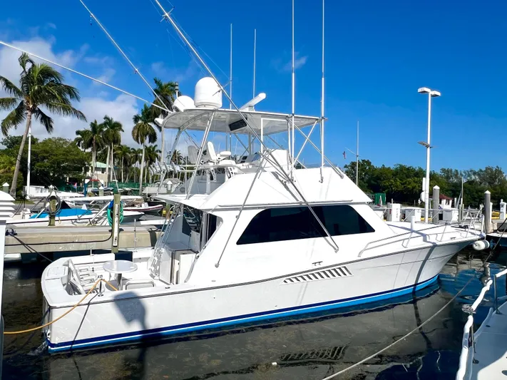 Bad Hatt Yacht Photos Pics 1999 Viking Conv Sport Fisher yacht docked at marina, surrounded by palm trees.