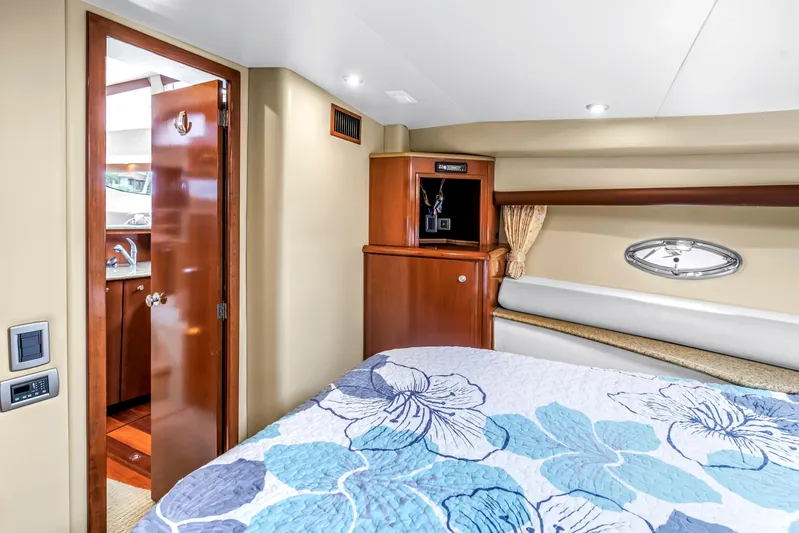  Yacht Photos Pics Interior of 2007 Meridian 459 Motoryacht bedroom with floral bedding and wooden cabinetry.
