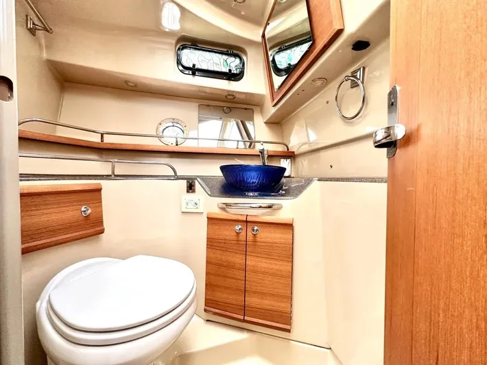  Yacht Photos Pics 2015 Ranger Tugs R-29S bathroom with modern sink, wooden cabinetry, and compact design.