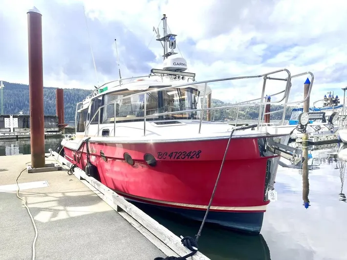  Yacht Photos Pics 2015 Ranger Tugs R-29S boat docked at marina, red hull, calm water, overcast sky.