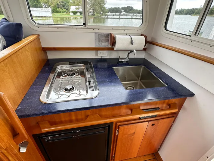  Yacht Photos Pics Compact kitchen area in 2016 Custom Broad Creek 32 Downeast boat with stove and sink.