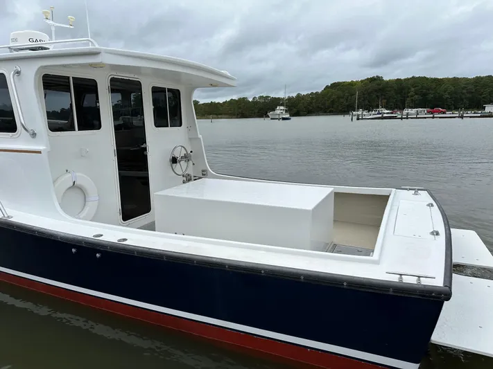  Yacht Photos Pics 2016 Custom Broad Creek 32 Downeast boat docked on a calm river.