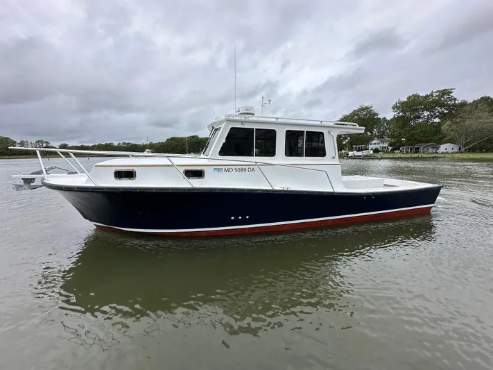  Yacht Photos Pics 2016 Custom Broad Creek 32 Downeast boat on calm water under cloudy skies.