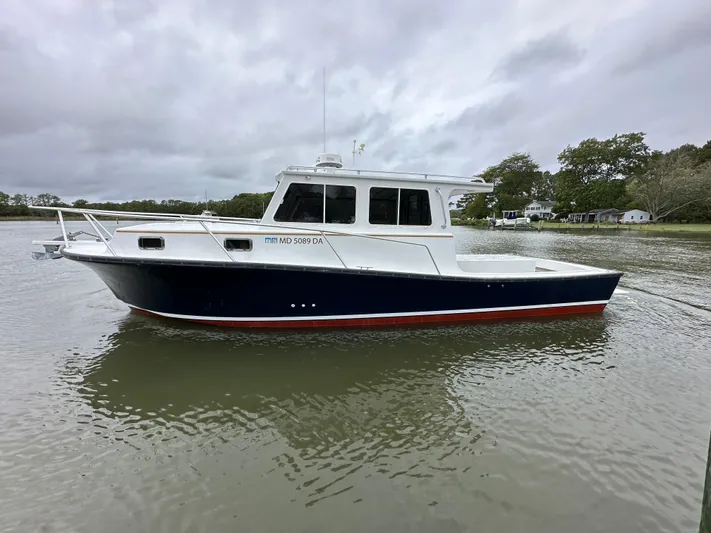  Yacht Photos Pics 2016 Custom Broad Creek 32 Downeast boat on calm water, overcast sky.