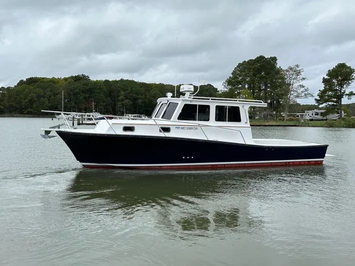  Yacht Photos Pics 2016 Custom Broad Creek 32 Downeast boat on calm water, overcast sky.