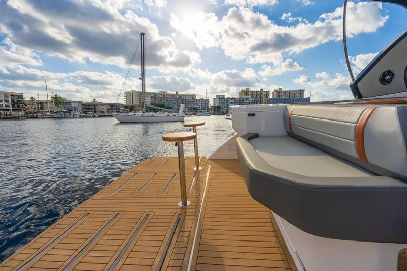  Yacht Photos Pics Luxury Hanover 377 yacht deck with seating, overlooking marina and sailboat, under a partly cloudy sky.