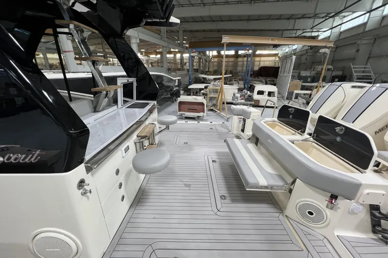  Yacht Photos Pics 2025 Scout 530 LXF luxury boat interior with seating and modern amenities in a warehouse setting.