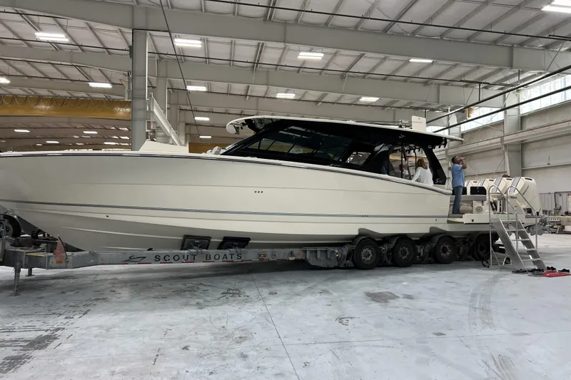  Yacht Photos Pics 2025 Scout 530 LXF boat in a spacious indoor facility on a trailer.