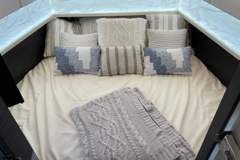  Yacht Photos Pics Luxurious cabin interior of 2025 Scout 530 LXF with cozy bedding and decorative pillows.