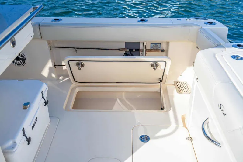  Yacht Photos Pics 2026 Scout 288 LXF boat interior with storage compartments and seating, on water.