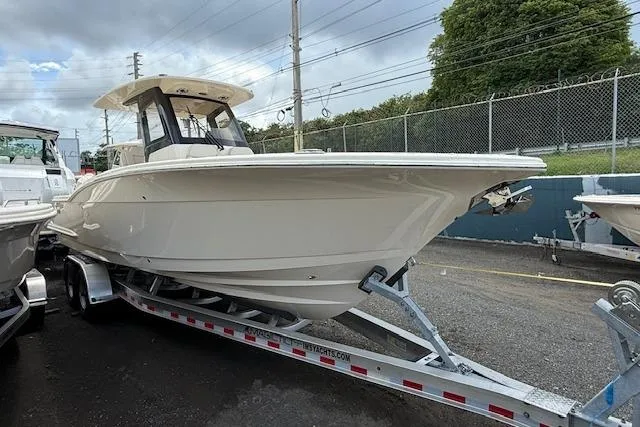  Yacht Photos Pics 2026 Scout 288 LXF boat on trailer, parked outdoors, cloudy sky background.